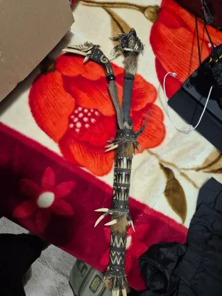 Bastón ceremonial tribal con dientes y plumas