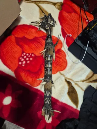 Bastón ceremonial tribal con dientes y plumas