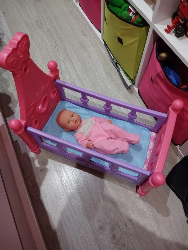 Cuna de muñeca rosa y morada ,con su muñeca.