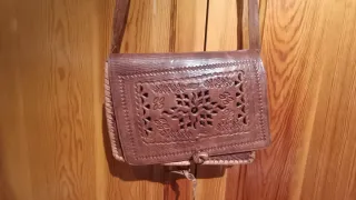 Bolso de cuero marrón con diseño floral