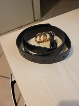 Cintura nera con fibbia dorata a cerchi