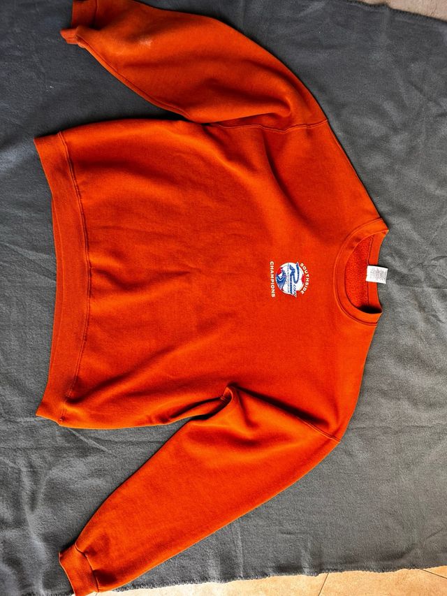 Sudadera naranja con estampado blanco,azul y rojo