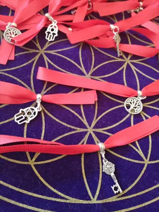 Pulseras de cinta roja con amuletos.Protección.