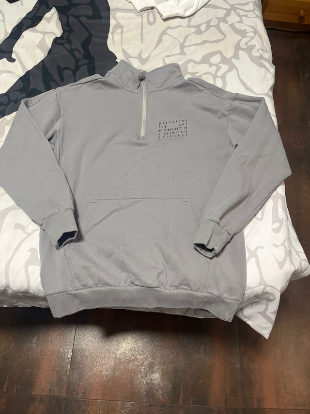 Sudadera gris con cremallera y bolsillo