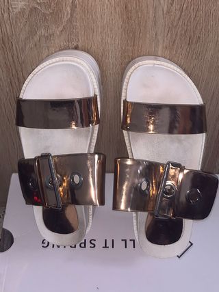 Sandalias doradas y blancas