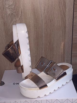 Sandalias doradas y blancas