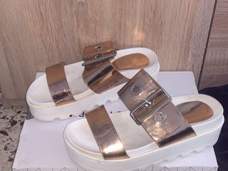 Sandalias doradas y blancas