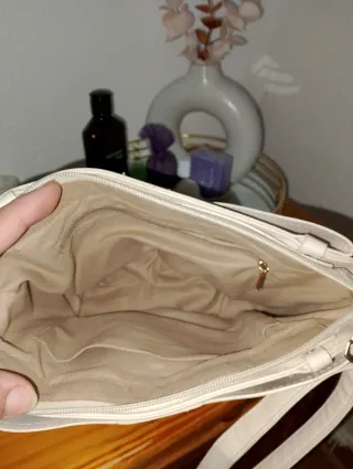 Bolso beige con muchos complementos