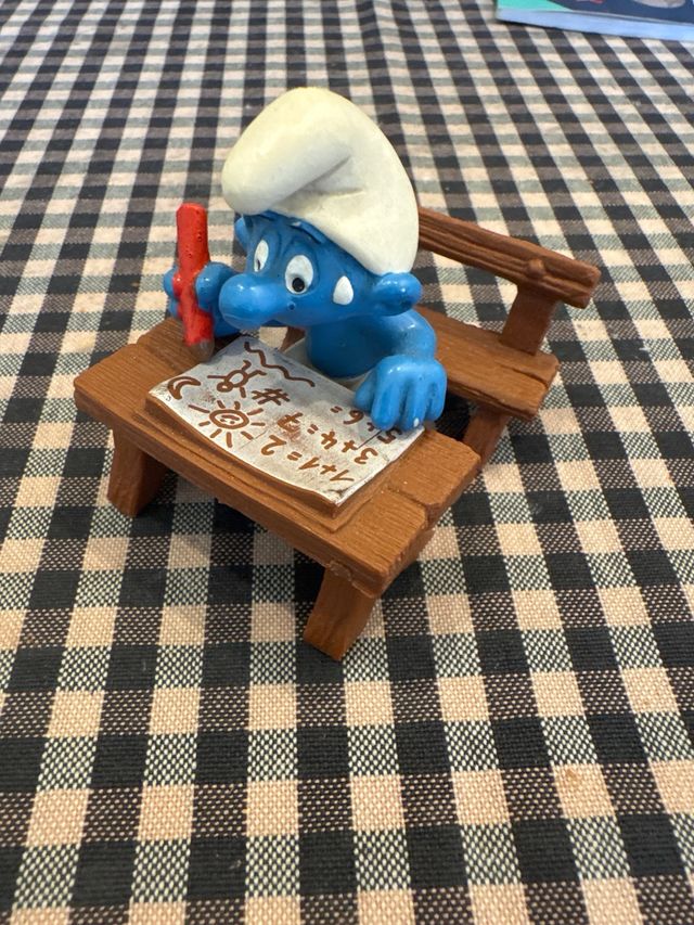 Pitufo estudiante con pupitre y lápiz