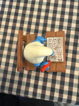 Pitufo estudiante con pupitre y lápiz