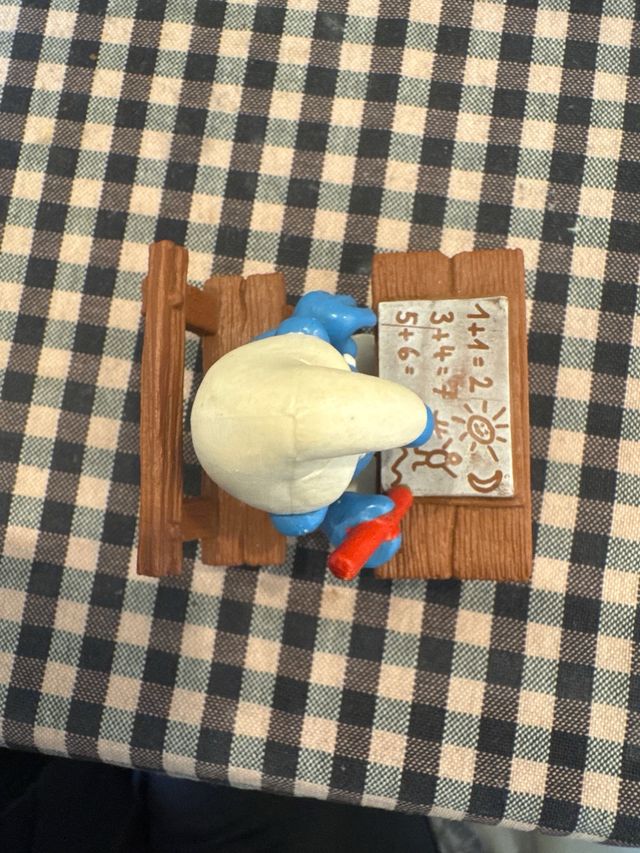 Pitufo estudiante con pupitre y lápiz