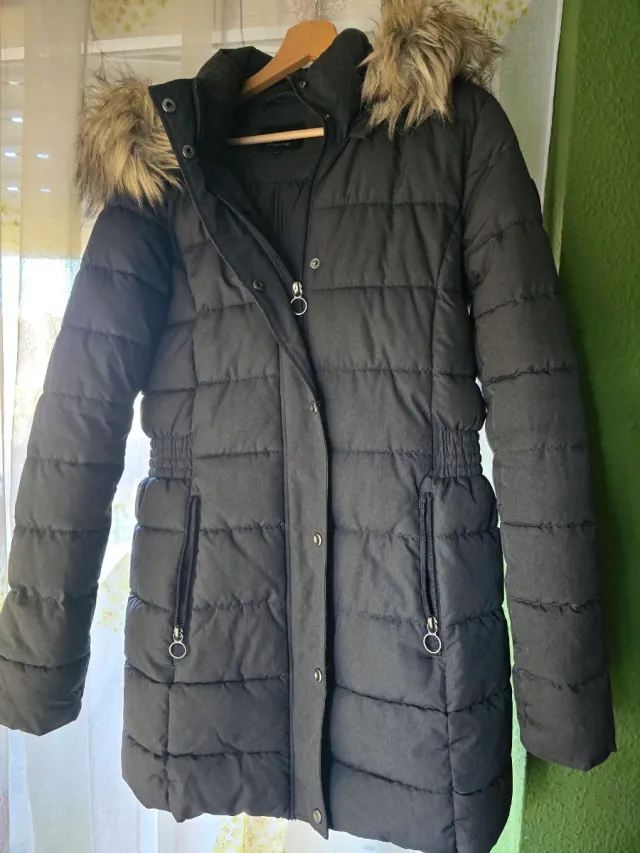 Abrigo acolchado grisaceo con capucha de pelo