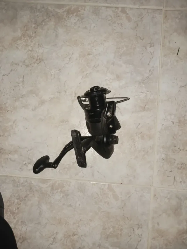 Carrete de pesca negro y caña