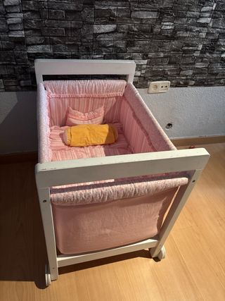 Cuna de bebé rosa con ruedas