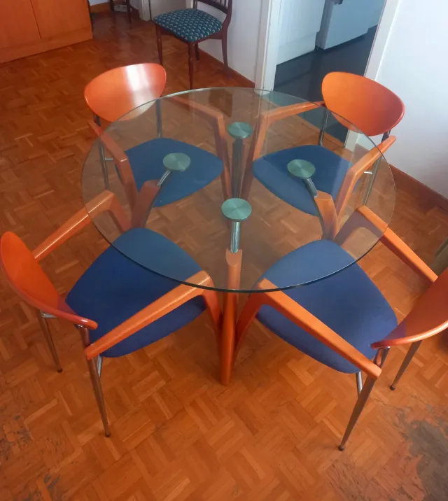 Mesa cristal redonda con 4 sillas naranjas