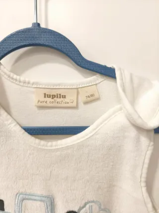 Pagliaccetto neonato bianco con trattore