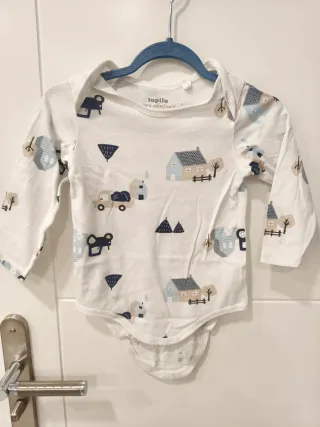 Pagliaccetto neonato bianco con trattore