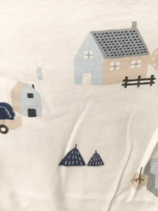 Pagliaccetto neonato bianco con trattore