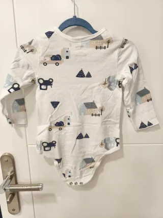 Pagliaccetto neonato bianco con trattore