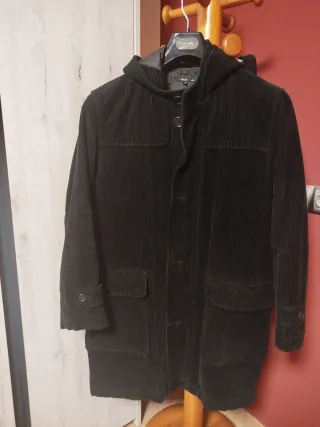 Abrigo negro de pana con capucha.