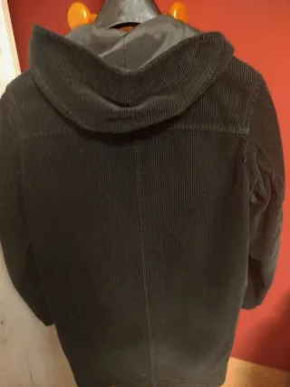 Abrigo negro de pana con capucha.