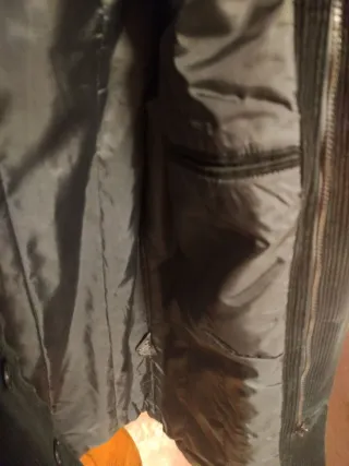 Abrigo negro de pana con capucha.