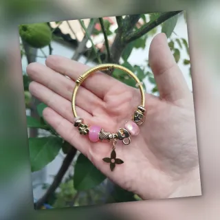 Pulsera dorada con charms rosas