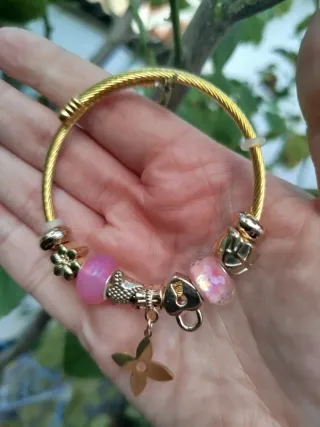 Pulsera dorada con charms rosas
