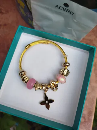 Pulsera dorada con charms rosas