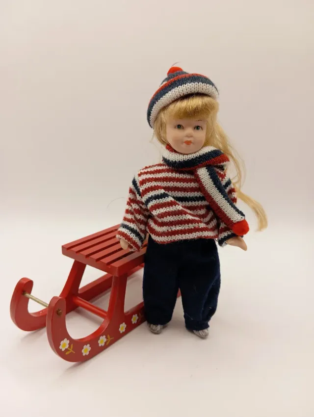 Bambola in porcellana da collezione con slitta