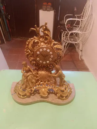 Reloj de sobremesa y candelabros dorados