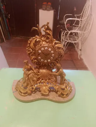 Reloj de sobremesa y candelabros dorados