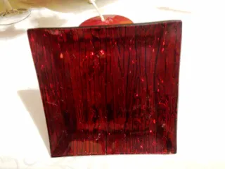 Candela rossa su porta candela in vetro