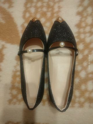 Zapatos negros con detalle dorado