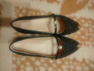 Zapatos negros con detalle dorado