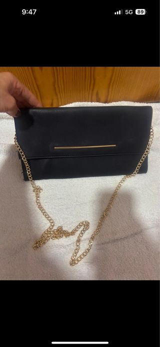 Bolso de mano negro con cadena dorada