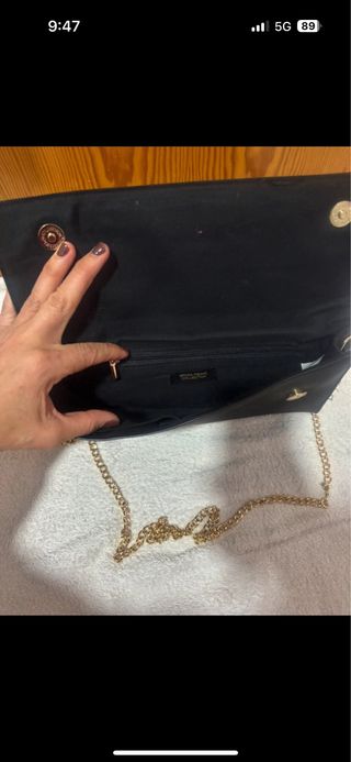 Bolso de mano negro con cadena dorada
