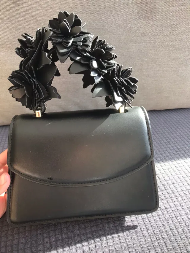 Bolso de mano negro con flores