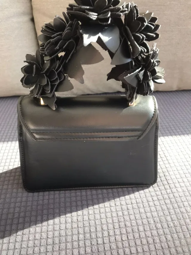Bolso de mano negro con flores