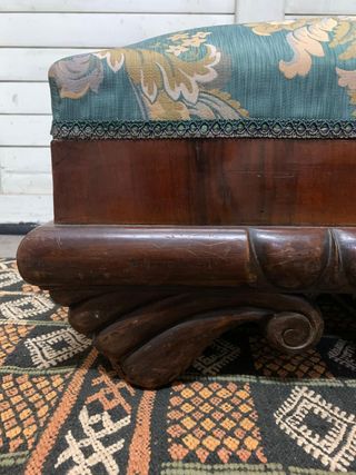 Puf baúl tapizado y con patas de madera.