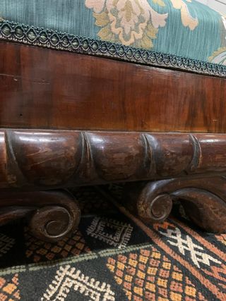 Puf baúl tapizado y con patas de madera.