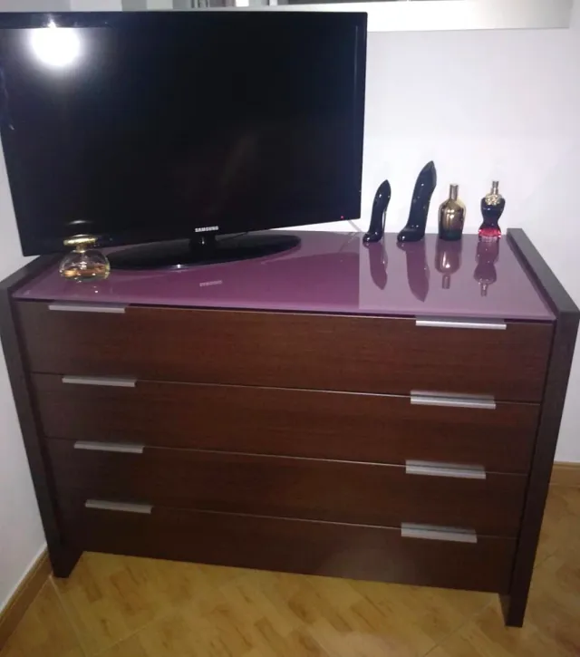 Mesitas de noche y cómoda de madera y cristal.