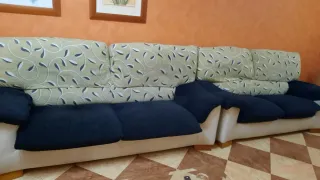 Dos sillones de tres y dos plazas de tela y piel.