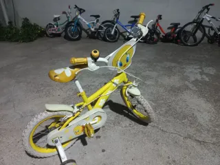 Bicicleta infantil amarilla con ruedas de apoyo