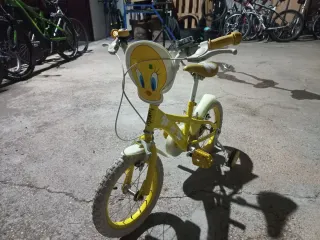 Bicicleta infantil amarilla con ruedas de apoyo