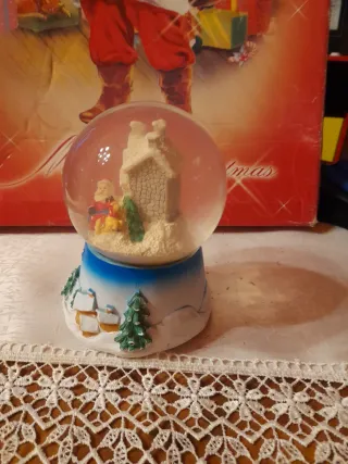 Palla di vetro natalizia con casetta e carillon.