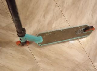 Patín de trucos azul con ruedas naranjas