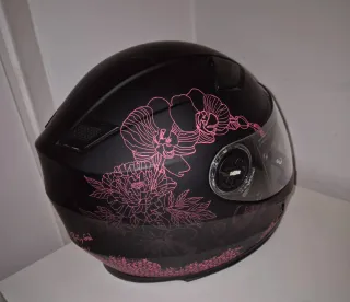 Casco de moto negro con detalles rosas