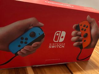 Nintendo Switch en caja con 4 controles