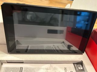 Nintendo Switch en caja con 4 controles